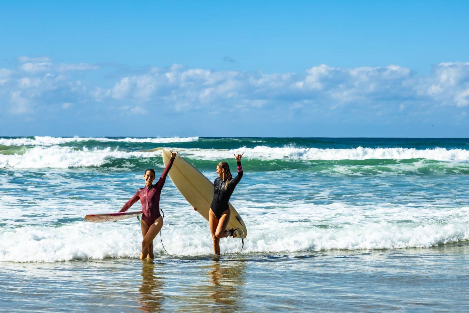 Two surfers walking out of the sea with their boards