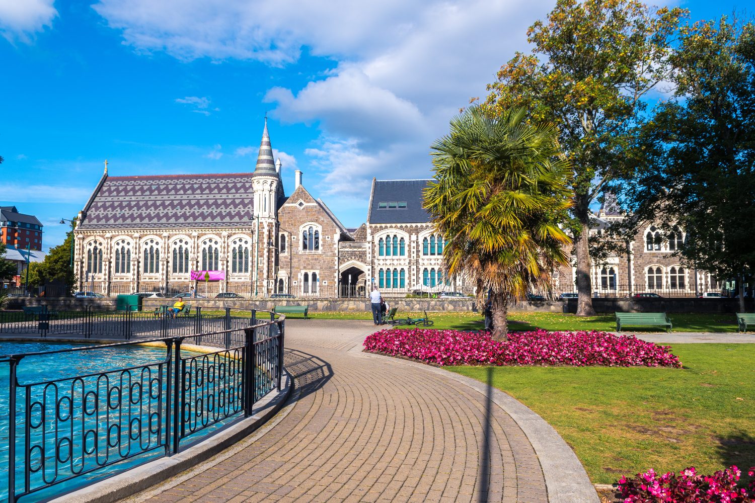 Heritage stone buildings, palms and flower beds in central Christchurch