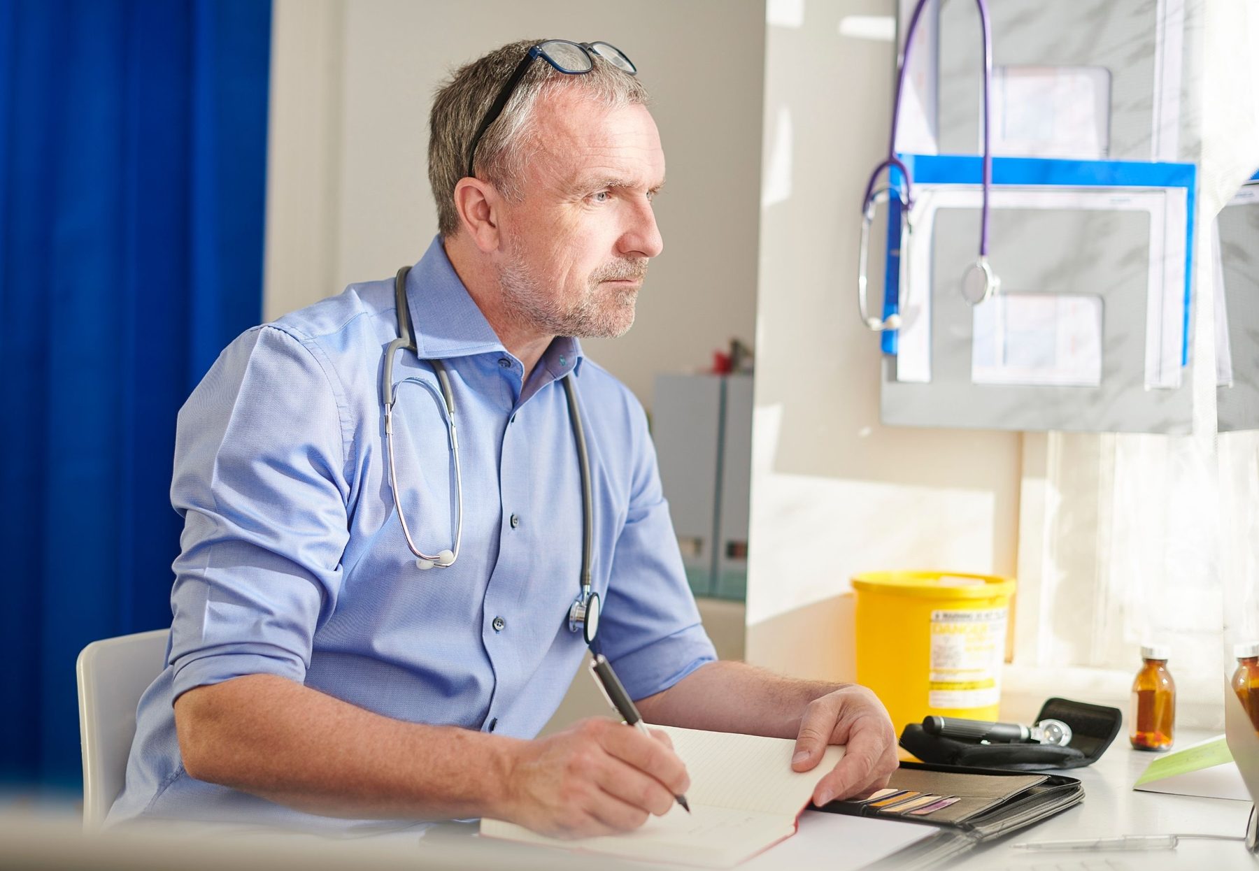 A clinician making notes at a desk