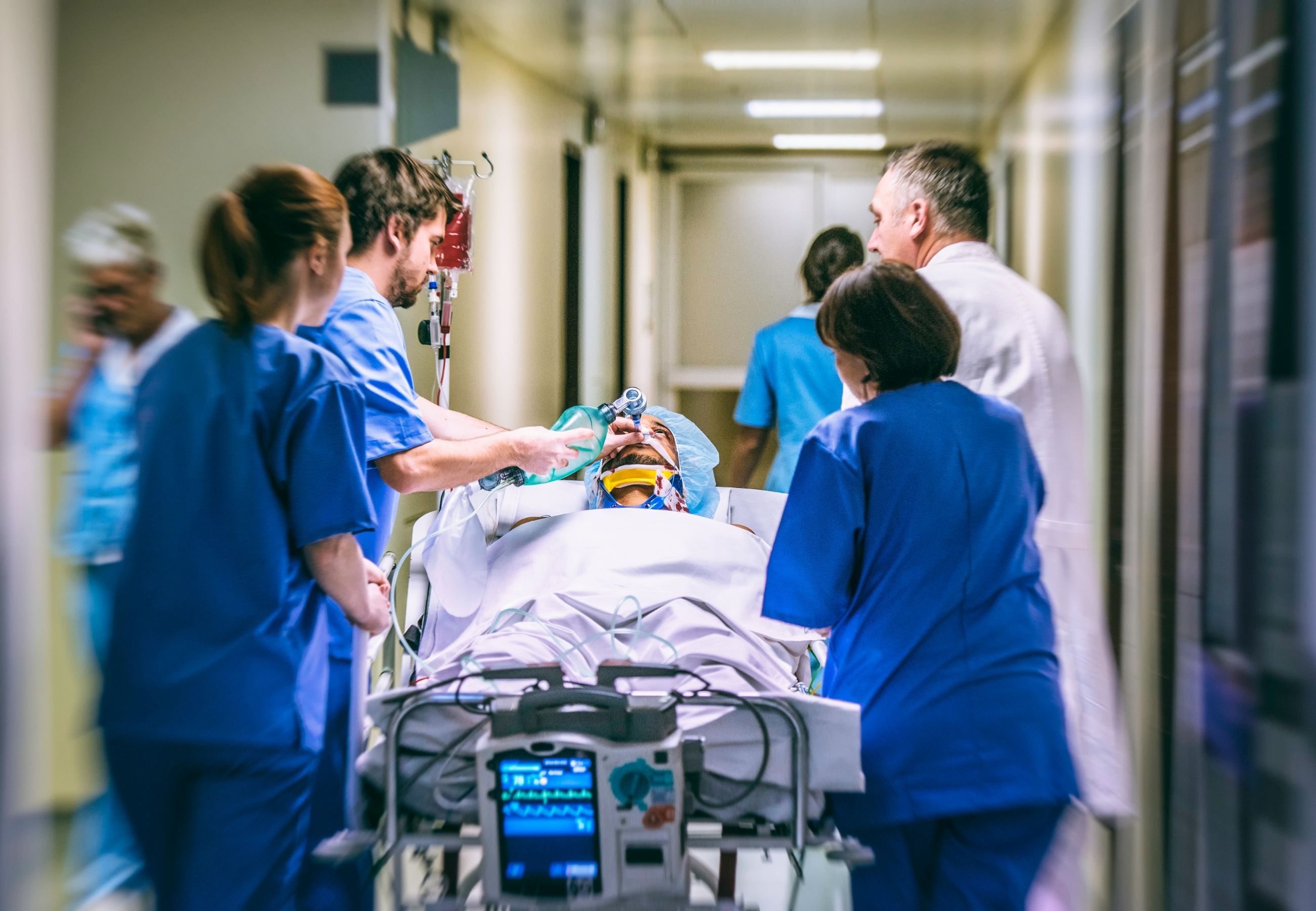 A clinical team moving a patient along a hospital corridor