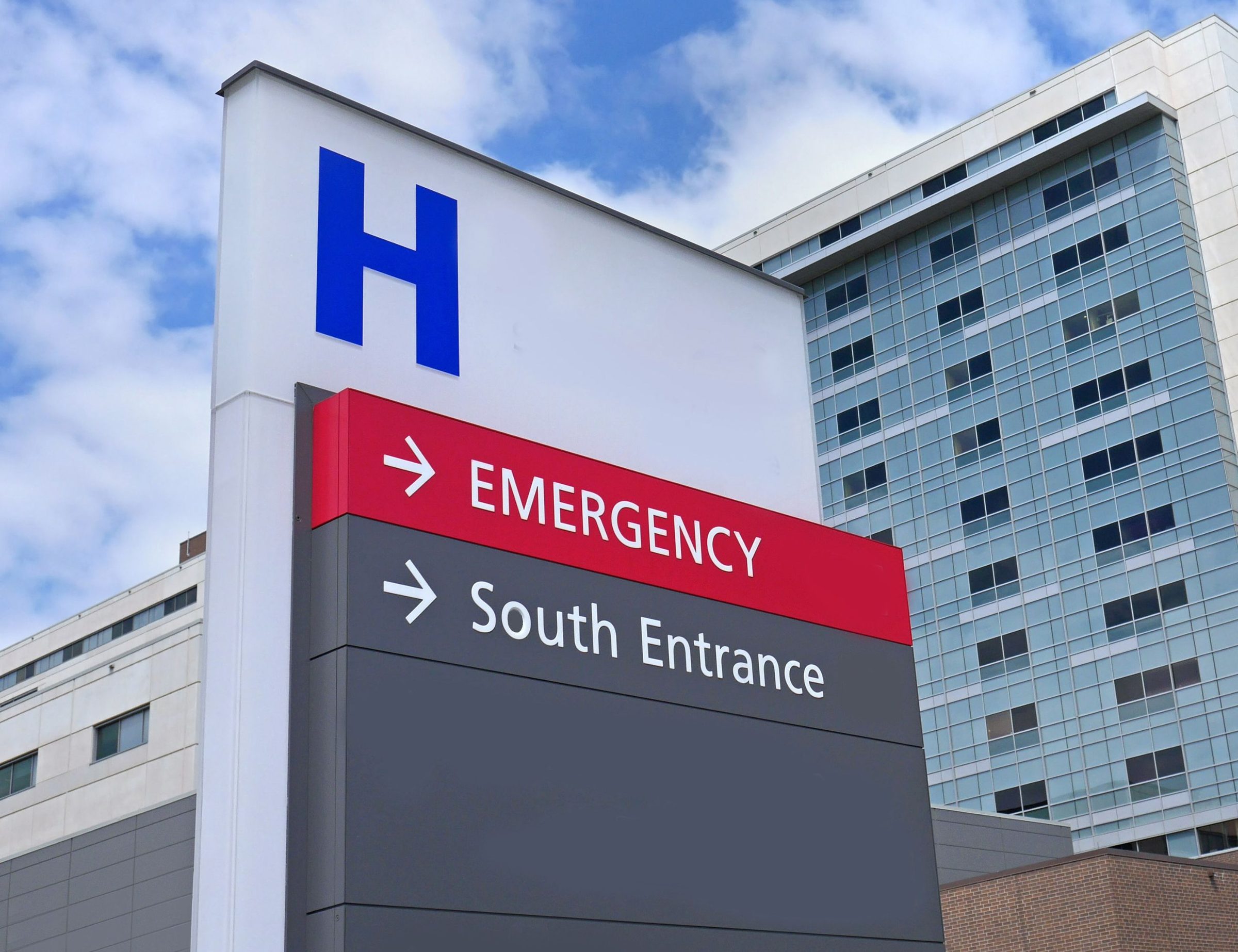 A hospital building with a red Emergency entrance sign