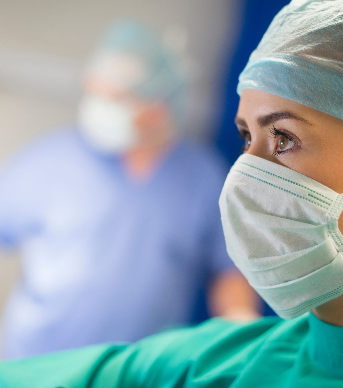 A theatre clinician in a mask, with the team behind