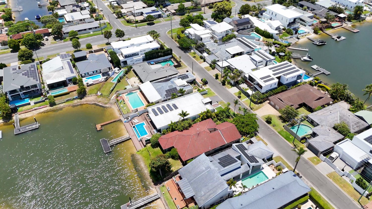 Aerial view of waterfront canal homes with boats and pools on the Gold Coast