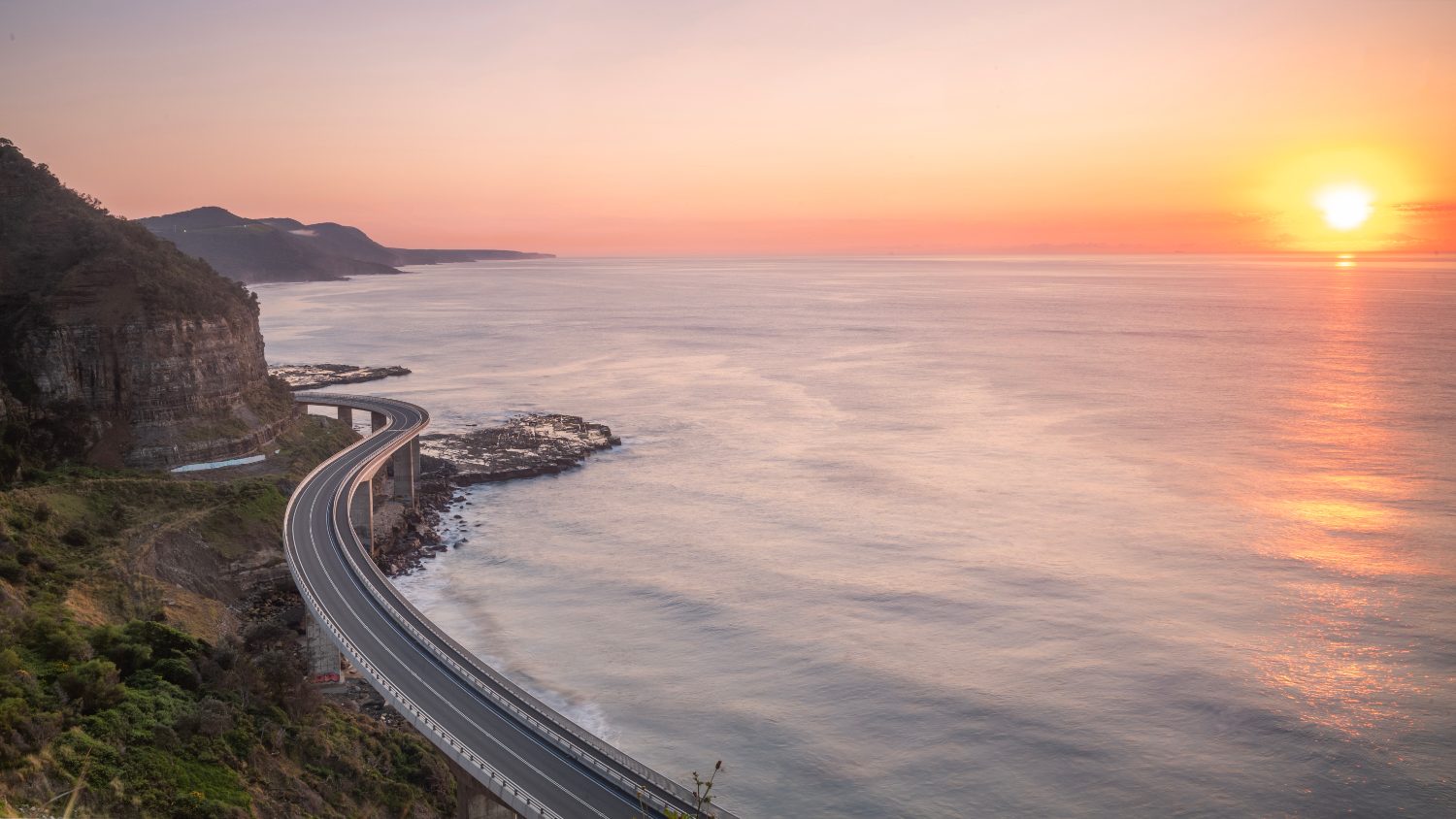The Sea Cliff Bridge curving around a cliff face above the ocean south of Sydney
