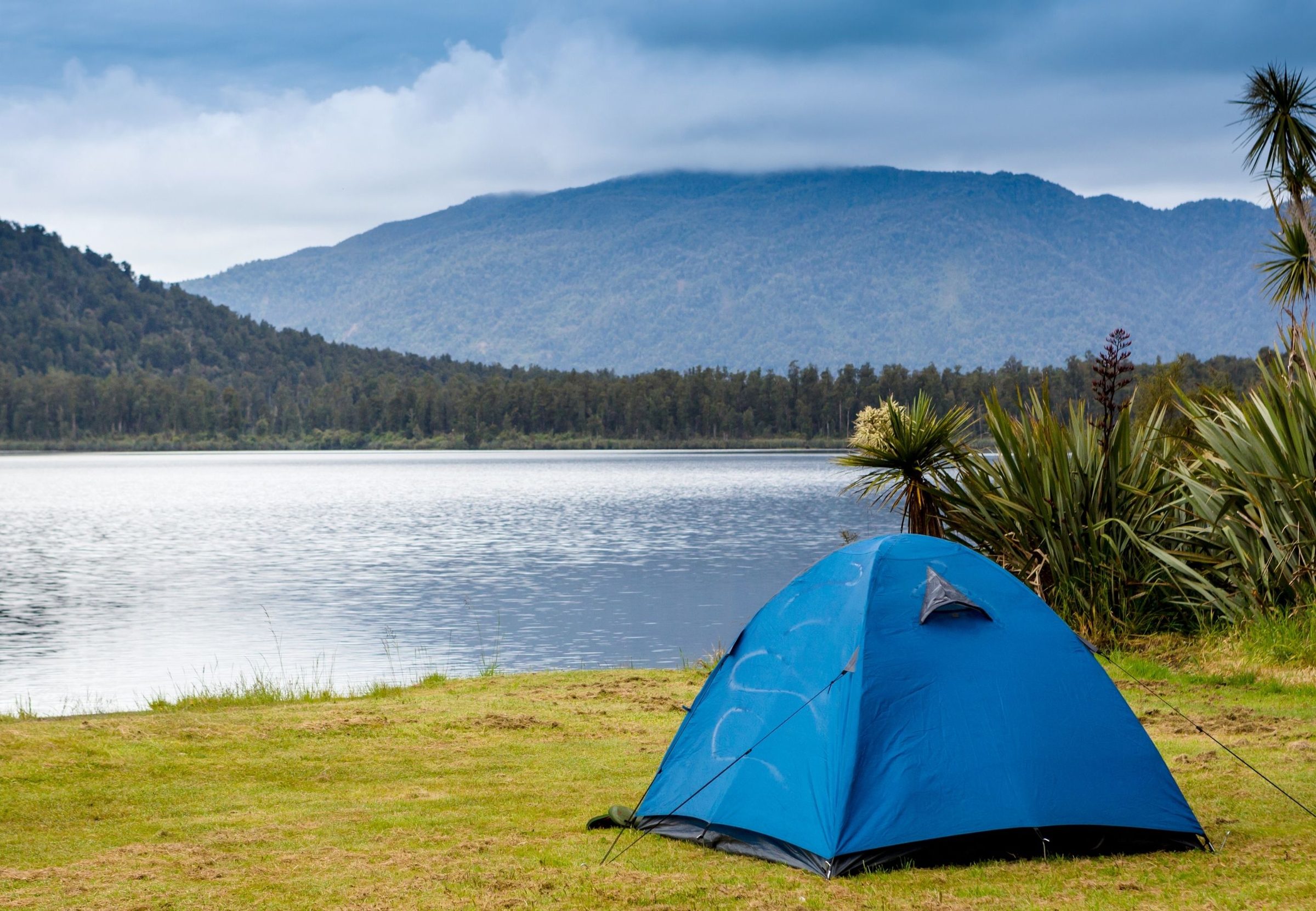 A tent pitched beside a lake at dusk