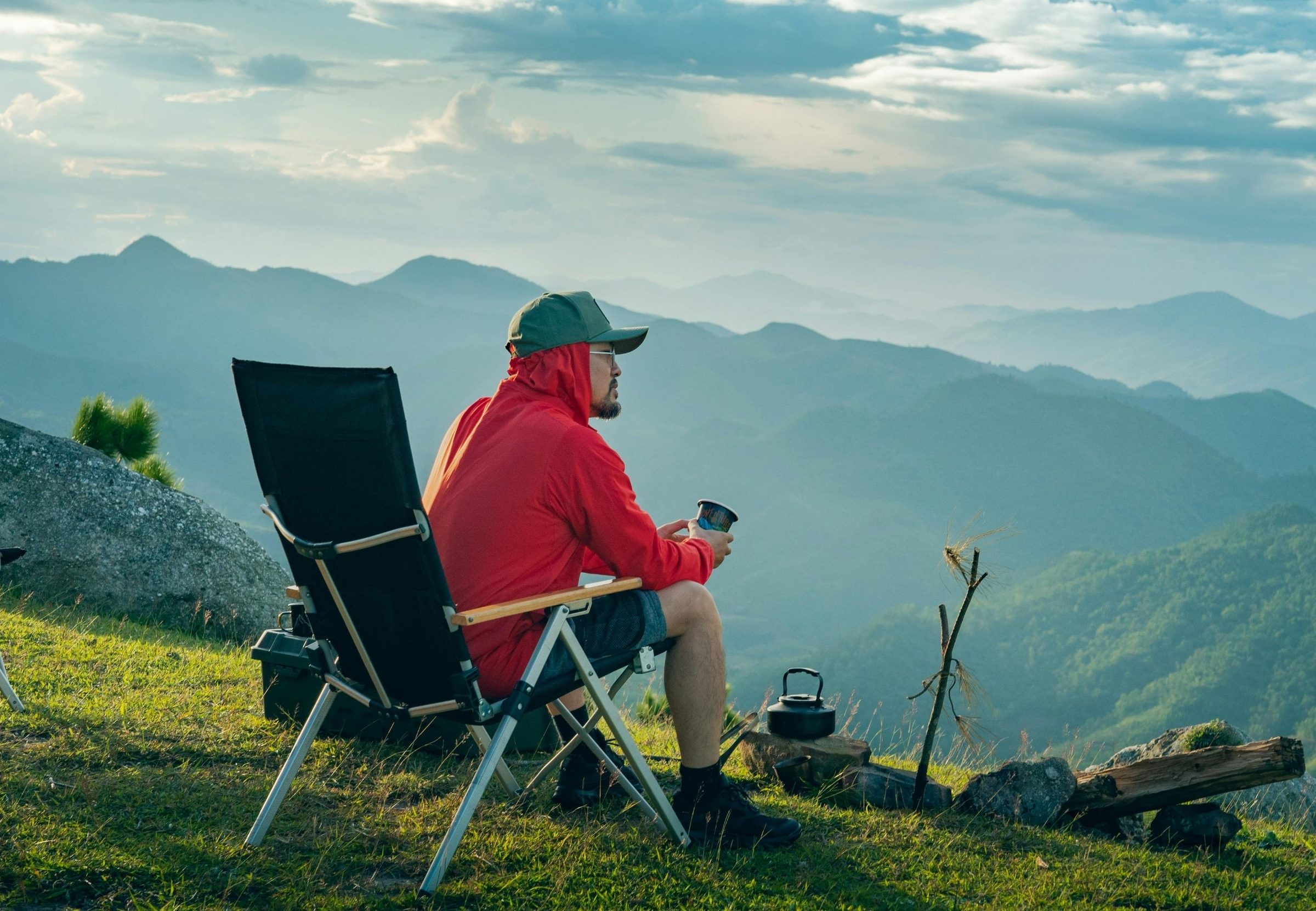 A camp chair facing mountains at the end of the day