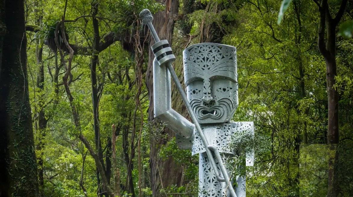 A carved pouwhenua standing against the sky