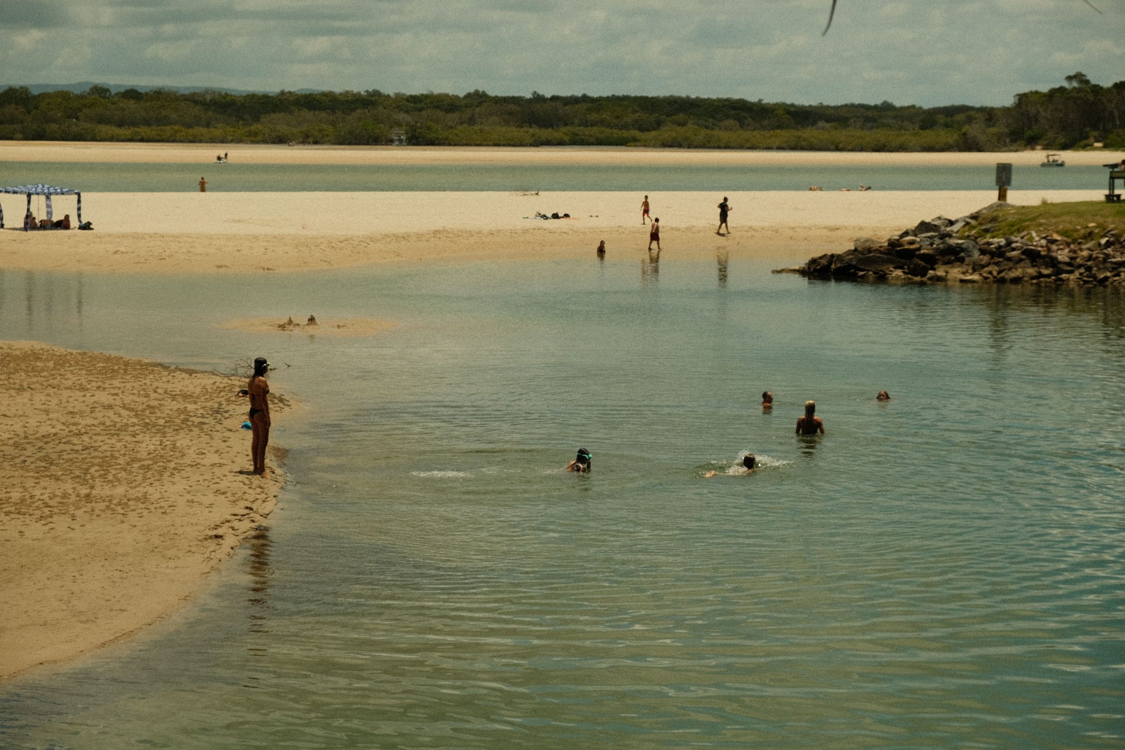 Swimmers at the mouth of a tidal creek in Queensland