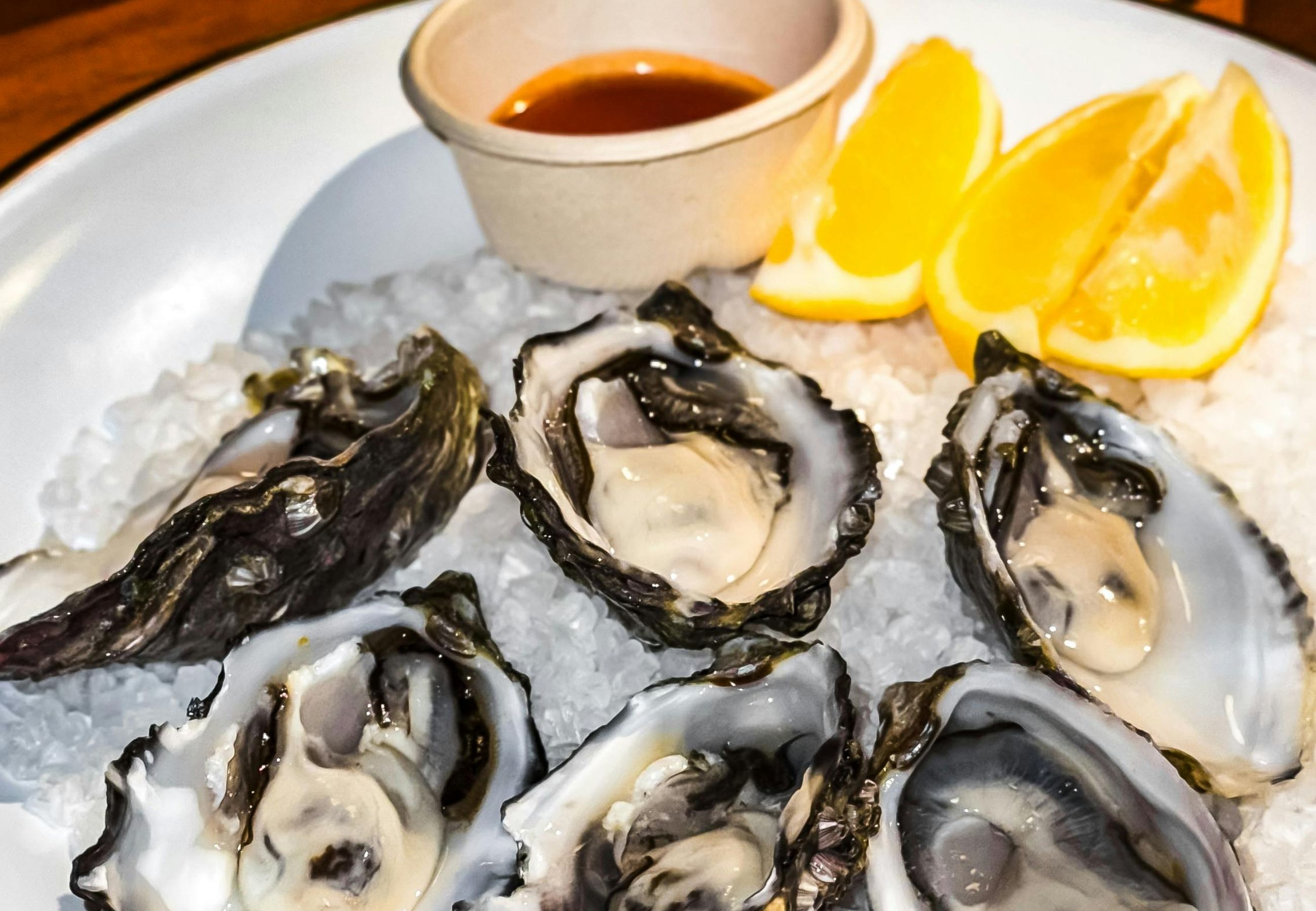 Fresh oysters on ice with lemon wedges