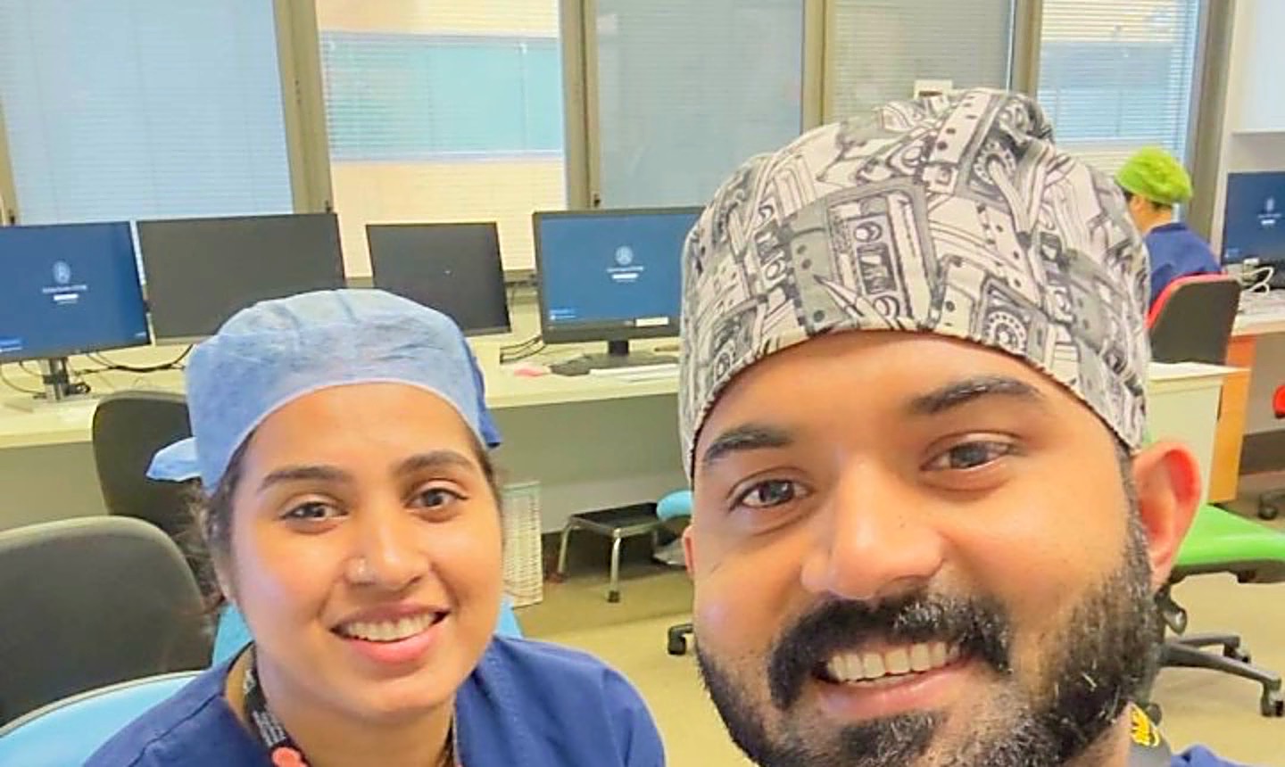 Amal and Sandra in theatre scrubs and caps at work in Wellington