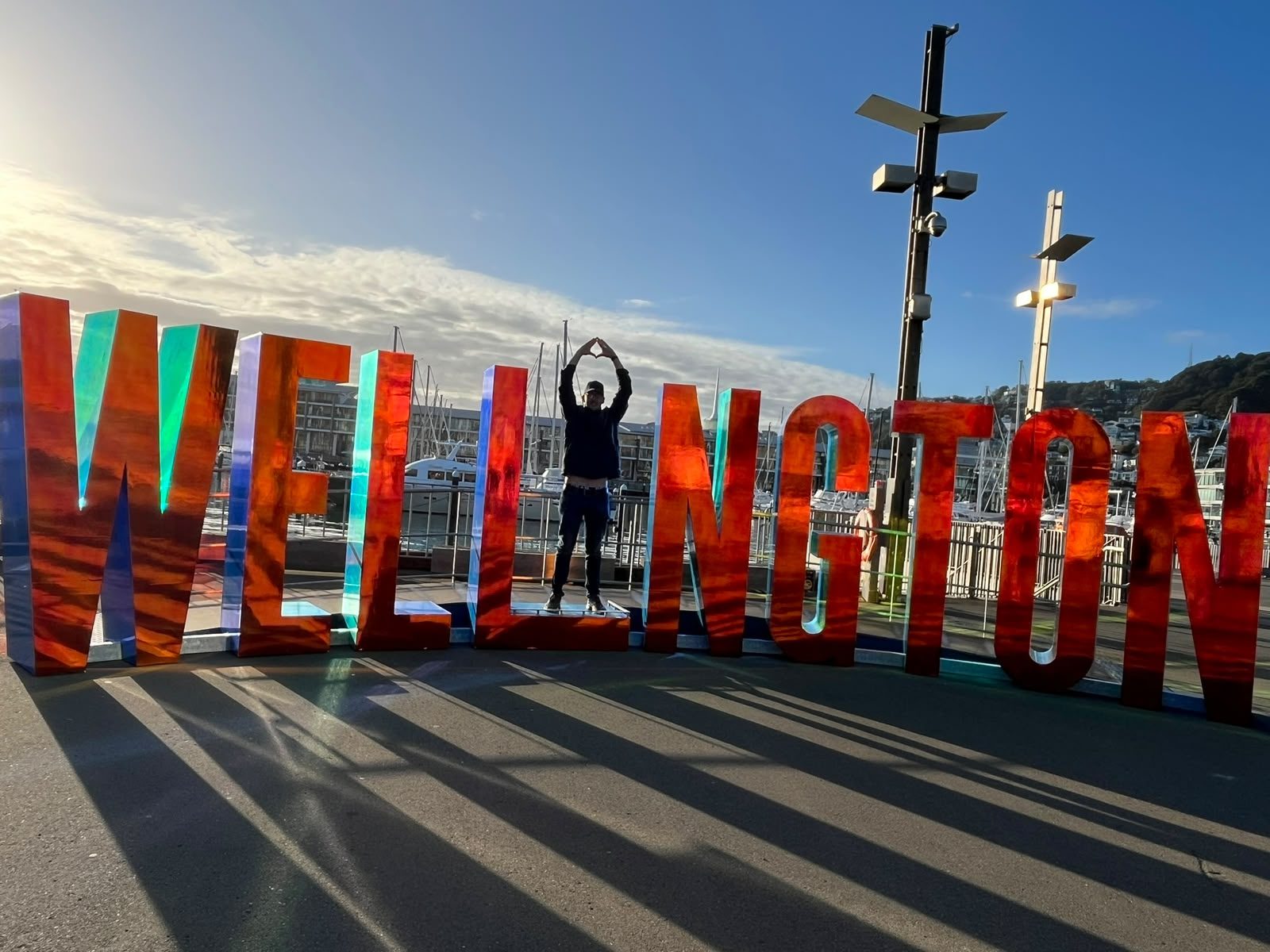 A visitor standing in the gap of the giant WELLINGTON letters on the waterfront