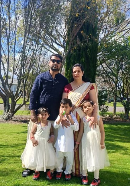 Rezon, his wife and their three children in traditional Onam clothes on a lawn in Palmerston North