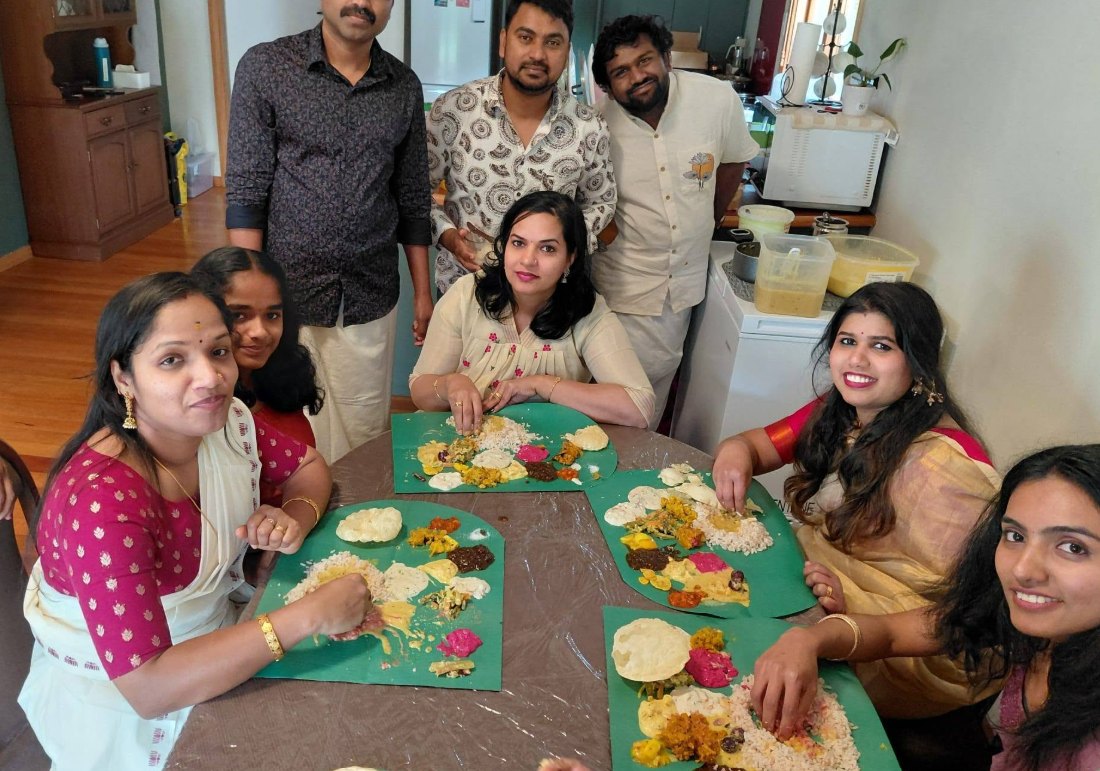 Anu, Rezon and friends sharing an Onam sadya on banana leaves at home in Palmerston North