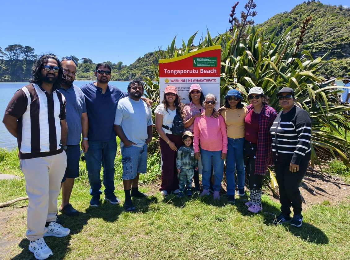 Friends and their families by the Tongaporutu Beach sign on the Taranaki coast