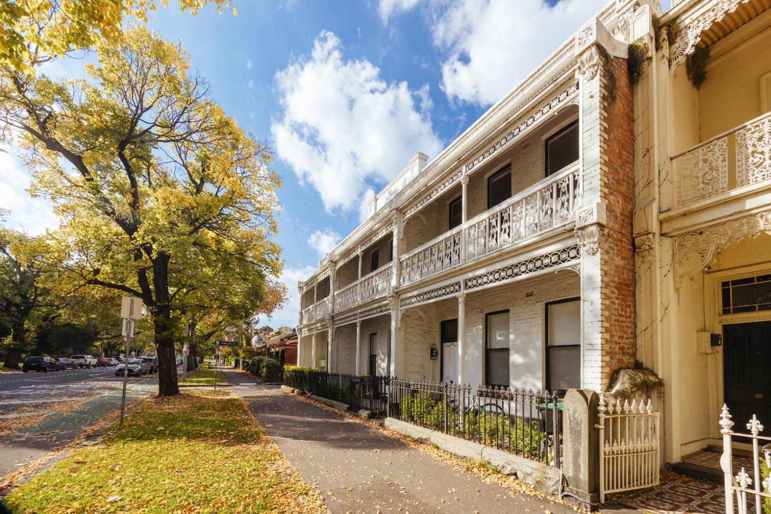 Victorian terrace houses with iron lacework on a leafy Melbourne street