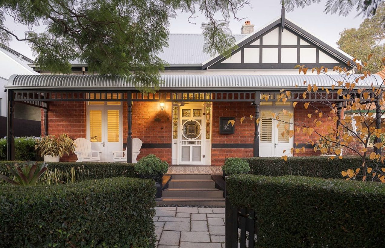 A brick-and-timber character house behind a clipped hedge in Subiaco